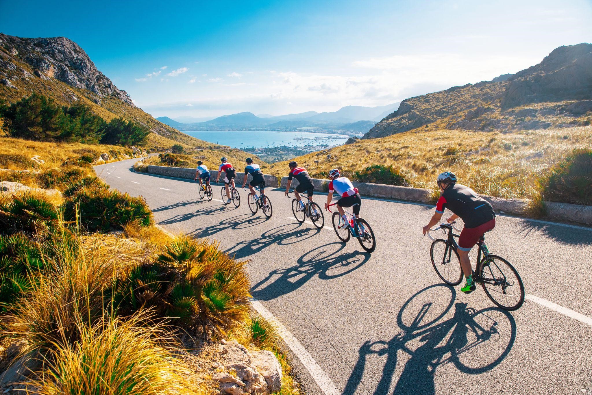 Road cyclists riding through a valley with beautiful surroundings 